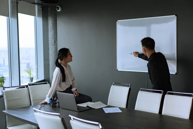 Colleagues engage in a productive office meeting with a whiteboard presentation. B2B demand generation ad rules explained for briefing teams