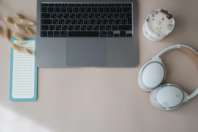 A top view of a minimalist desk setup featuring a laptop, headphones, and a notepad. Why B2B demand generation attribution methods disagree with each other